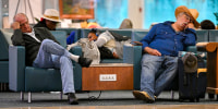 Travellers sleep on chairs during flight delays at Orlando International Airport in Florida on Oct. 30, 2025, after the Federal Aviation Administration (FAA) said the airport had no certified air-traffic controllers in its tower, forcing arrivals to be halted or severely delayed.