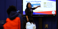 A teacher teaches about gun safety.