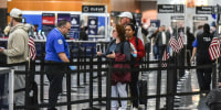 Image: Travelers make their way through a security line