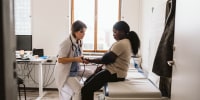 Female healthcare worker measuring young patient's blood pressure in medical clinic