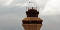 A plane takes off past the FAA tower at St. Louis-Lambert International Airport 