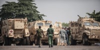 Members of the Nigerian and United States military discuss as they stand next to some of the 24 armoured vehicles donated to the Nigerian government in Jan. 2016.