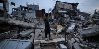 A displaced Palestinian boy stands on the ruins of destroyed buildings in the Bureij refugee camp, in the central Gaza Strip, on Nov. 29.