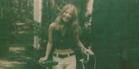 Rhonda Marie Fisher posing with a bike and smiling.