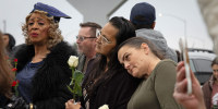 People lean on each other at a vigil on Nov. 30, 2025 in Stockton, Calif., for the victims of a shooting at a family party.