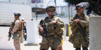 Members of the California National Guard and U.S. Marines guard a federal building