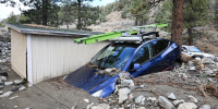 A car is buried in mud after a series of storms Thursday, Dec. 25, 2025, in Wrightwood, Calif. 