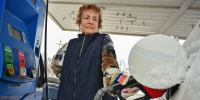A customer pumps gas in Schenectady, N.Y., on Dec. 3, 2025. 