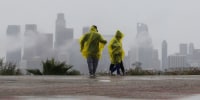 A family walks in the rain at Elysian Park on Dec. 24, 2025 in Los Angeles, California