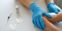 A doctor applies a patch after vaccination.