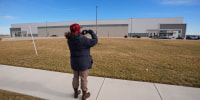 A man takes photos of a warehouse as federal officials tour the facility to consider repurposing it as an ICE detention facility Thursday, Jan. 15, 2026, in Belton, Mo. 