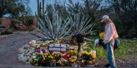 People stop at a makeshift memorial at the entrance to Nancy Guthrie's home on Feb. 12, 2026 in Tucson, Ariz.