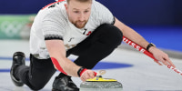 Yannick Schwaller of Switzerland thows a stone during Mixed Doubles round robin play against Team Estonia on Feb. 4, 2026 in Cortina d'Ampezzo, Italy.