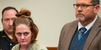 Rebecca Auborn standing in court next to a lawyer and police officer.