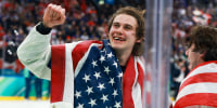 Jack Hughes of Team United States celebrates after their gold-medal win with an American flag draped over his back
