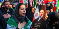 Image: A woman holds a picture of Iran's new Supreme Leader Ayatollah Mojtaba Khamenei