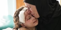 Amina presses her face to Malika's, wounded by shrapnel
