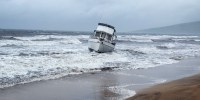 A boat is grounded on a beach by the shore