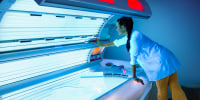 Woman prepares a tanning bed/solarium for sunbathing