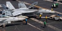 US sailors taxiing an F/A-18F Super Hornet, attached to Strike Fighter Squadron (VFA) 41, on the flight deck aboard Nimitz-class aircraft carrier USS Abraham Lincoln.