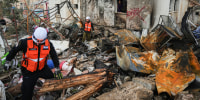 Israeli security forces survey the site that was struck by an Iranian missile