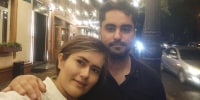 Safa Sefidgari, left, and her husband Ehsan Entezari stand outside for a selfie
