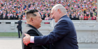 Image: Kim Jong Un greeting Belarus' President Alexander Lukashenko with a handshake and smile.