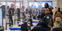 A TSA agent at a screening checkpoint.