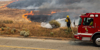 Firefighters battle the blaze at the site of the Springs Fire