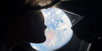 Artemis II mission specialist Christina Koch looks back at earth through the window of the Orion spacecraft on April 2, 2026. 