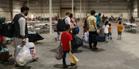 In this handout image Afghan Special Immigrants walk through the in-processing building