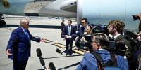 Donald Trump speaks to a group of reporters on the tarmac in front of Air Force One.