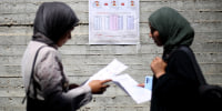 Women read instructions to voters ahead of the upcoming municipal elections in Deir el-Balah in the central Gaza Strip on April 21.