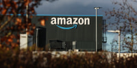 An Amazon warehouse as seen from outside through foliage