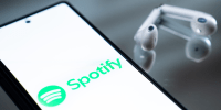 The Spotify logo appears on a smartphone screen.