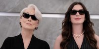 Meryl Streep and Anne Hathaway stand side by side wearing dark sunglasses.
