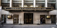 A brick building with tall windows and an awning with lettering: CHURCH OF SCIENTOLOGY OF NEW YORK.