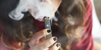 A person smokes an E-Cigarette. 
