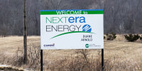 A sign for NextEra energy is seen outside along the side of a road
