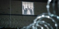 Detainees stand by a window inside the federal immigration center.