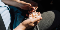 A man in a car takes out a nicotine pouch from a plastic jar