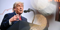 Donald Trump speaks while standing behind a podium