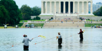 National Park Service employees and contractors use vacuums to remove green algae from the bottom of the Lincoln Memorial Reflecting Pool on June 18, 2026 in Washington.