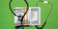 Photo illustration of stethoscope and a stack of one-hundred dollar bills