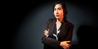Tamar Shirinian poses against a black background with her arms crossed