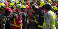 Rescue workers carry Hernán Alberto Flores Gil after he was pulled from the rubble in Venezuela's Earthquake.