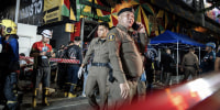 Police officers and emergency responders at the scene of a fire in Bangkok.