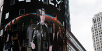 Elon Musk on screen in Times Square.