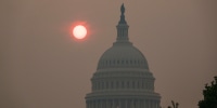 The sun rises behind the U.S. Capitol.