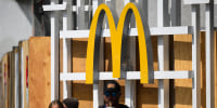 The McDonalds logo is displayed as people walk in the street.
